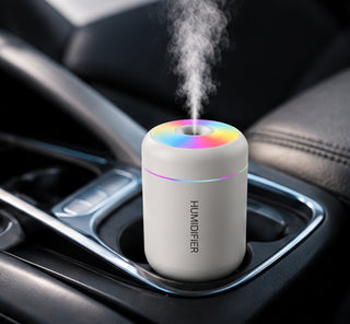Difusor blanco encendido en el posavasos de un coche