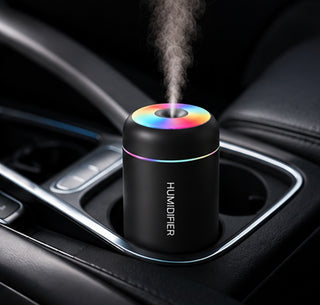 Difusor negro encendido en el posavasos de un coche